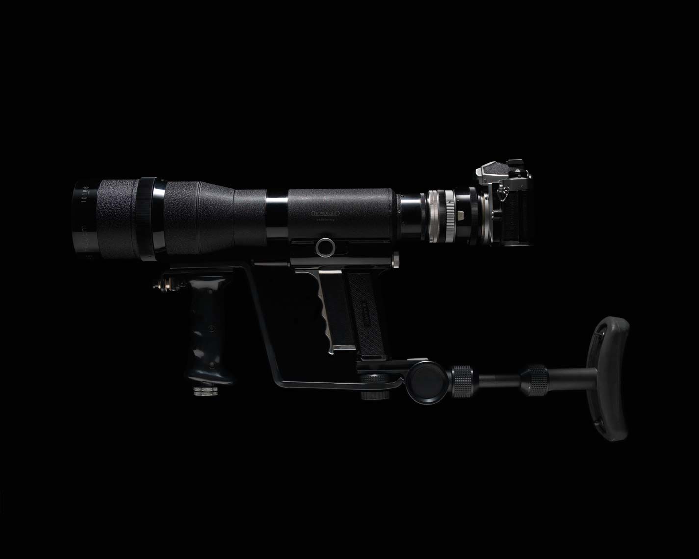 photo of a gunstock camera zoom lens on black