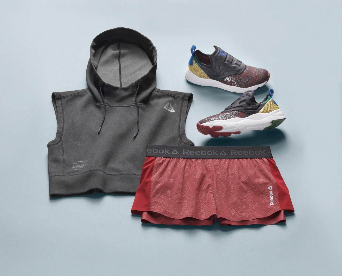 workout outfit on a light blue background sneakers hoody shorts