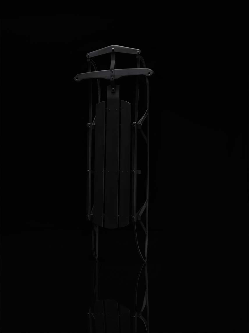 flexible flyer sled painted matte black on a black background