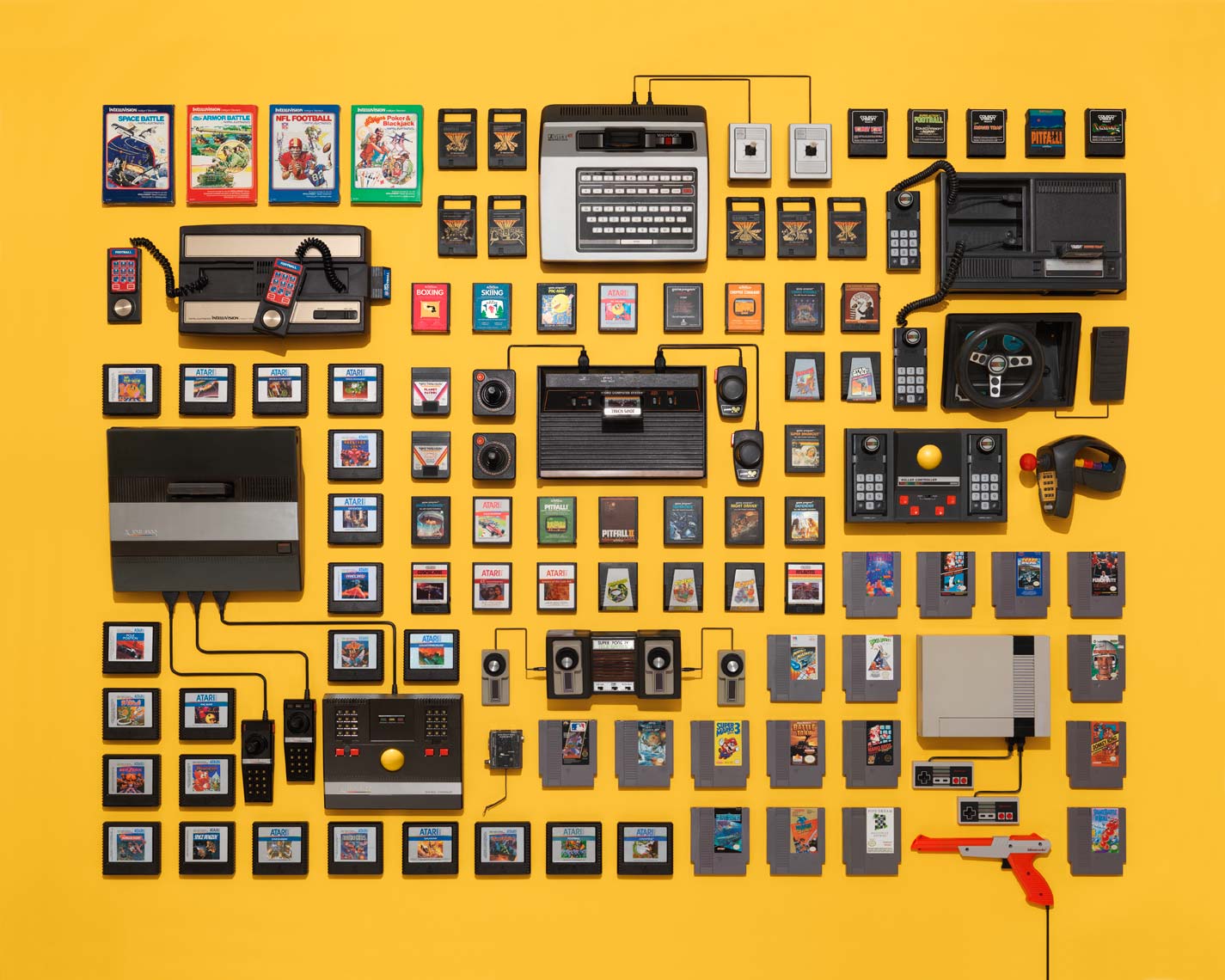vintage video game consoles and cartridges on a yellow background