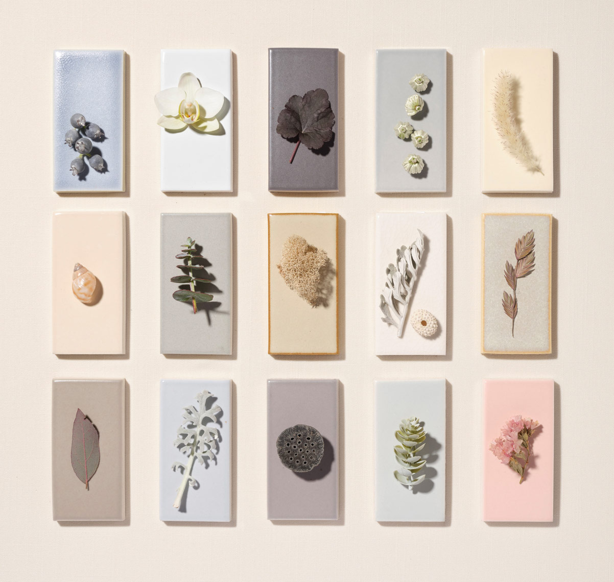 gridded collection of pastel colored ceramic tiles with dainty objects upon them Ann sacks tile
