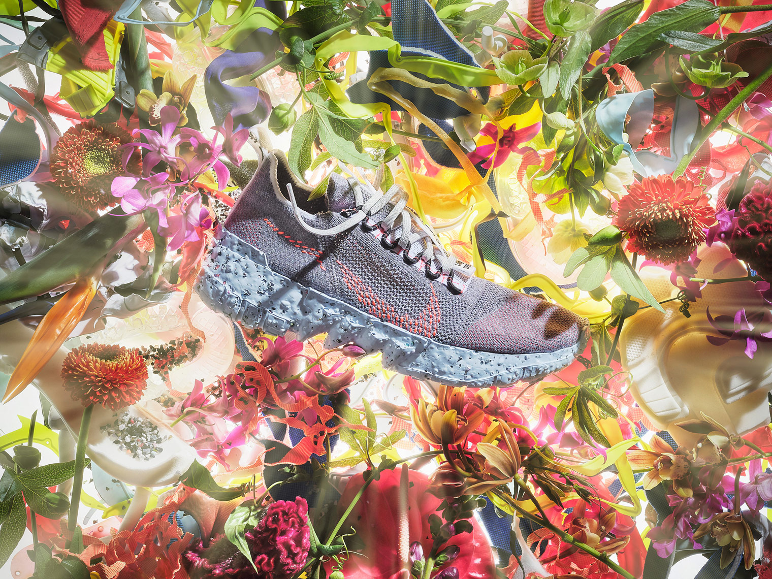 nike space hippie trainer on a bed of flowers with light rays