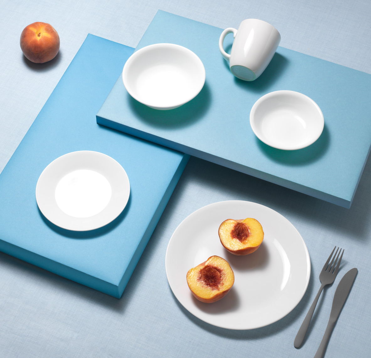 correlle plates and mug on blue with peaches