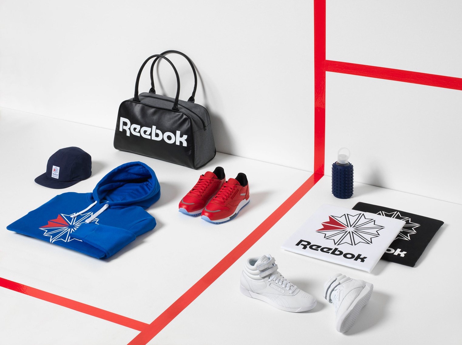 mens reebok sportswear on a white court with red stripe